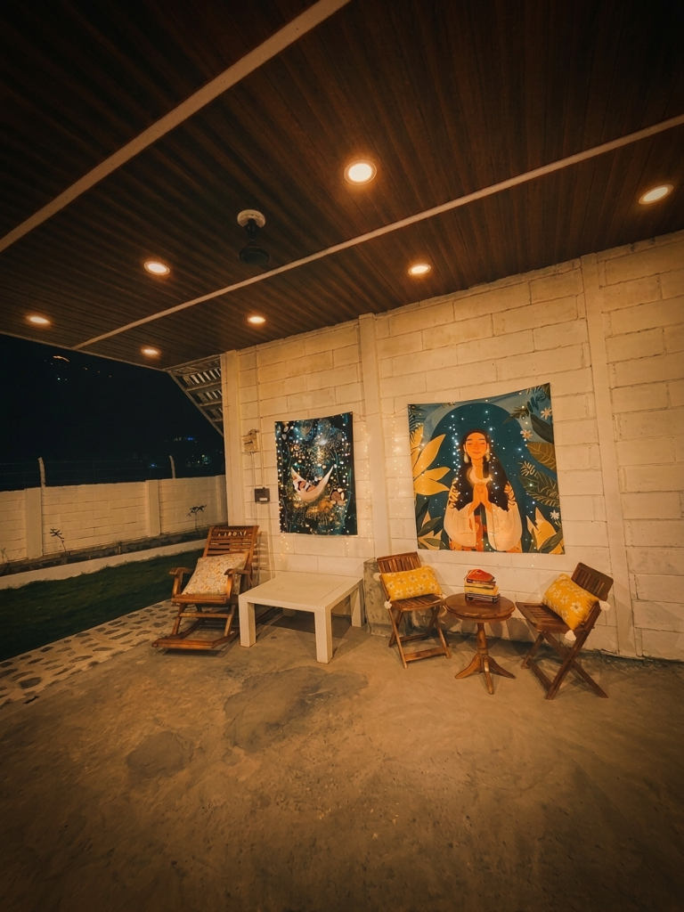 Open sitout with tapestries and lounge chairs at night