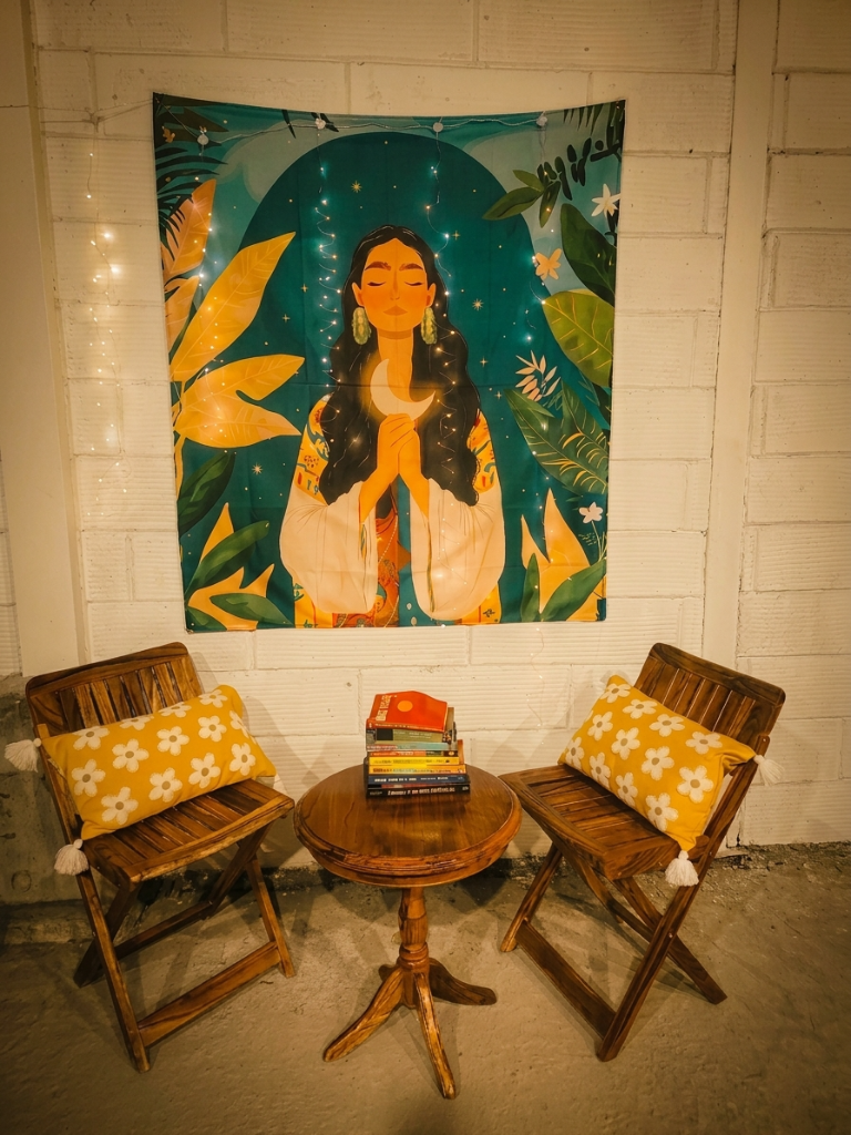 Boho seating nook with teak chairs and tapestry wall art