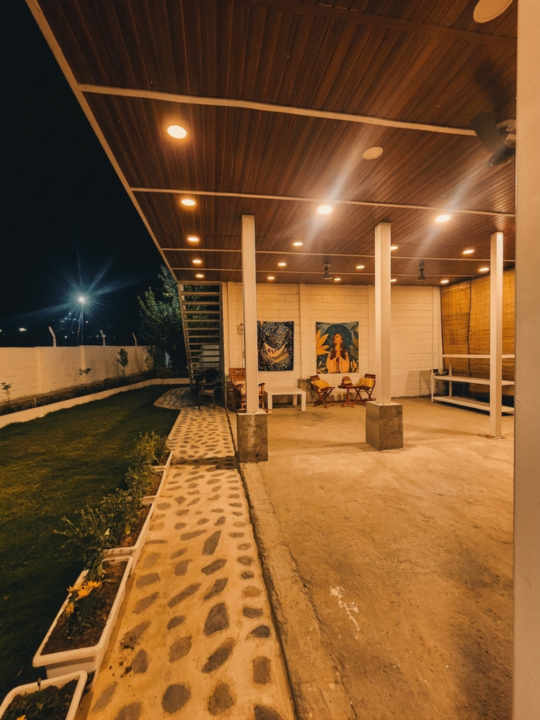 Covered verandah at night with tapestries and seating