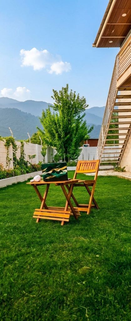 Wooden chairs on lawn with mountain backdrop