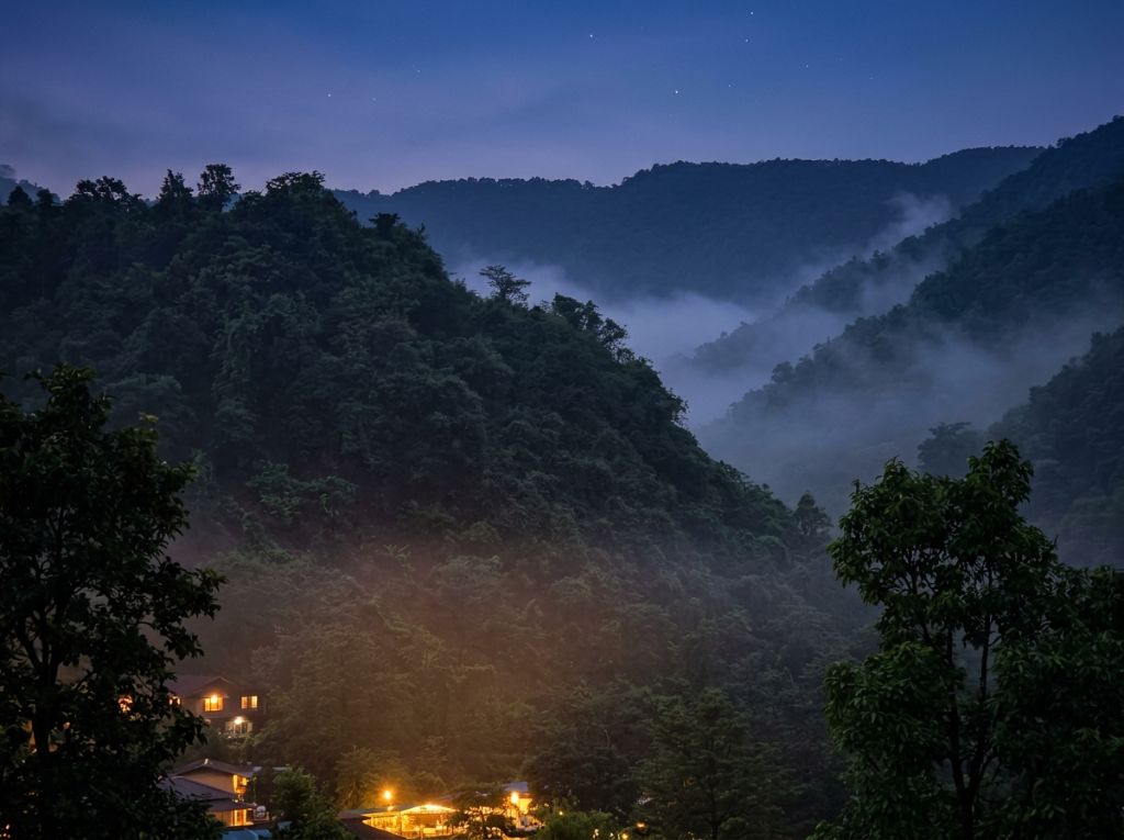 Misty valley lit at night